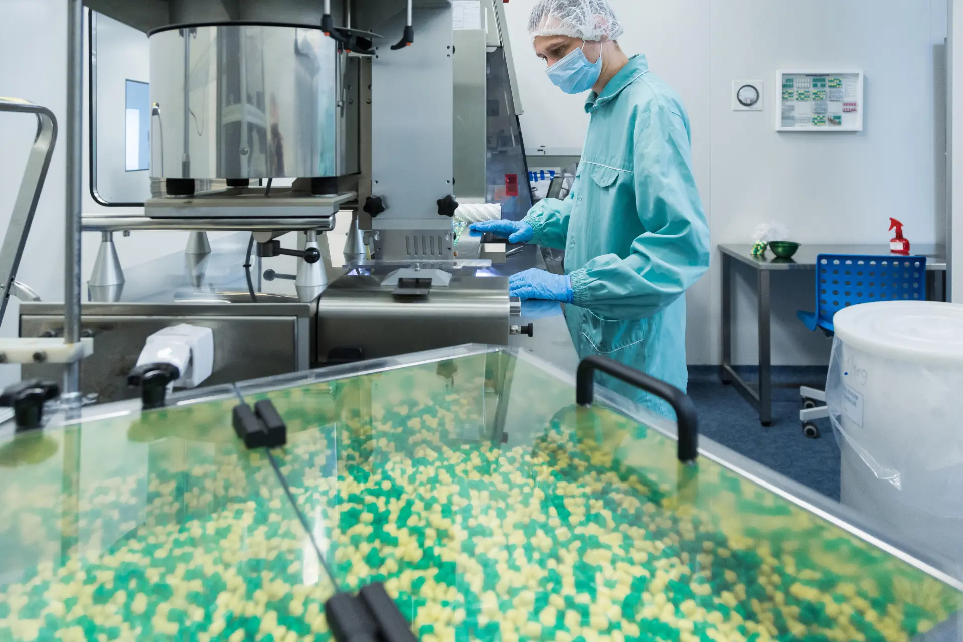 Technician inspecting capsules at the blister packing machine